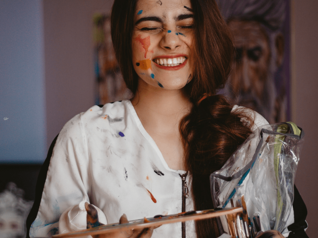 happy woman with paint splatters on face
