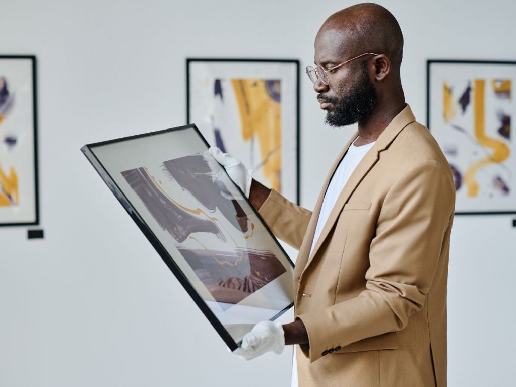 man holding a framed painting