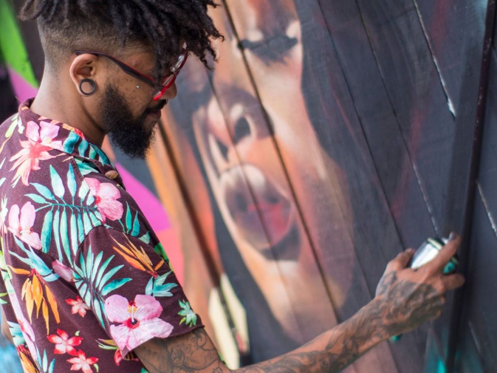 A mural artist spray painting a project